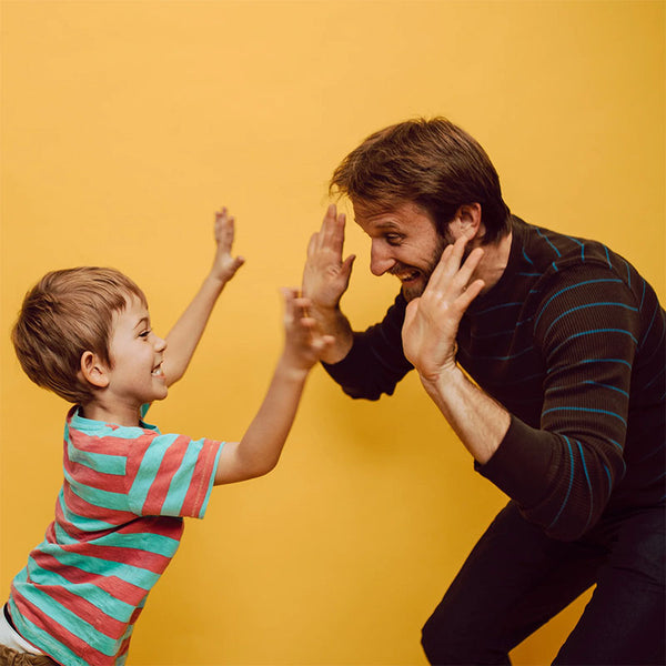 father and son doing high fives