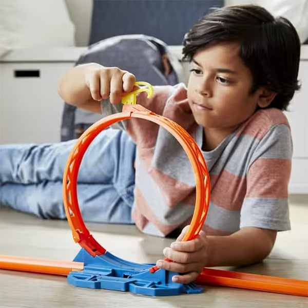 kid playing with hot wheels loop