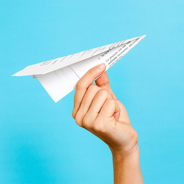 a hand holding a paper airplane