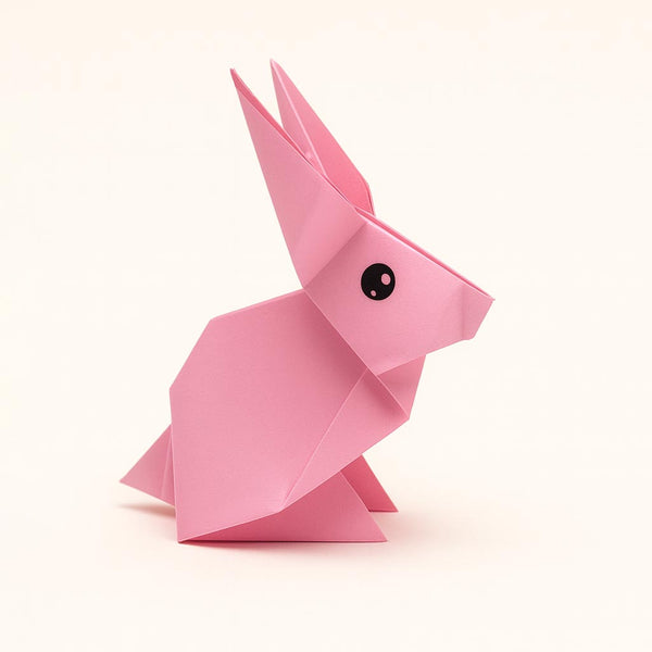Pink origami rabbit on a white background