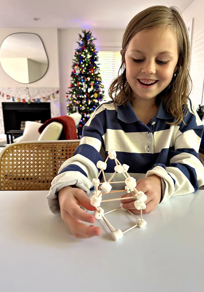 Girl holding a marshmallow snowflake she built